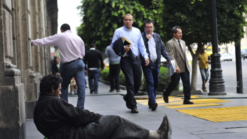 Foto: Un hombre pide en la calle de una zona financiera. (EFE)